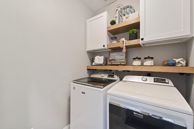 washroom featuring cabinet space and washer and clothes dryer