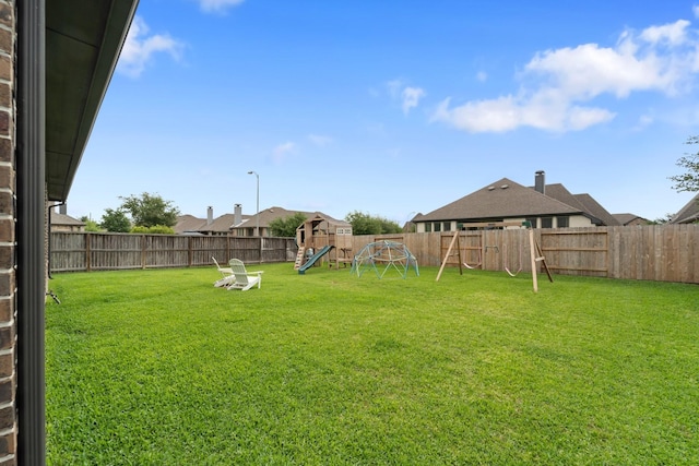 view of yard with a fenced backyard and a playground