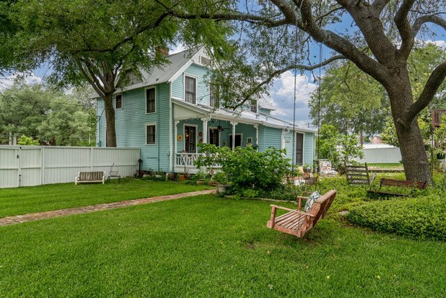 exterior space with a porch, fence, and a ceiling fan