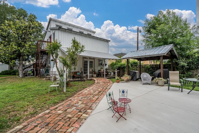 rear view of house with fence, a patio area, a gazebo, a yard, and stairway
