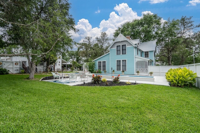 back of house with fence, stairs, a fenced in pool, a patio, and a yard
