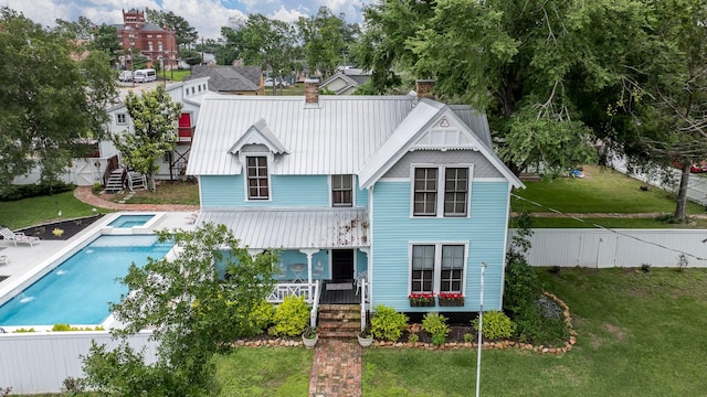 back of house with a lawn, stairway, and a chimney