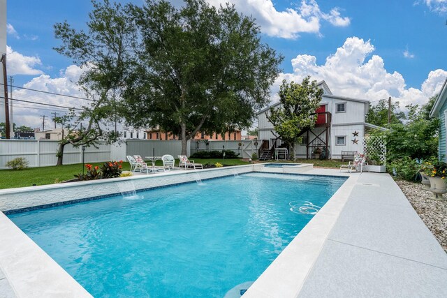view of swimming pool featuring stairs, fence, and a pool with connected hot tub