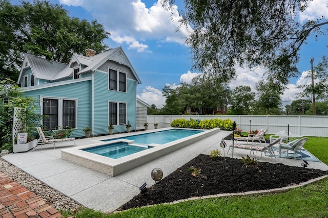 view of swimming pool featuring a fenced backyard, a patio, and a pool with connected hot tub