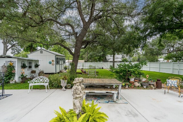 view of patio featuring an outdoor structure and a fenced backyard