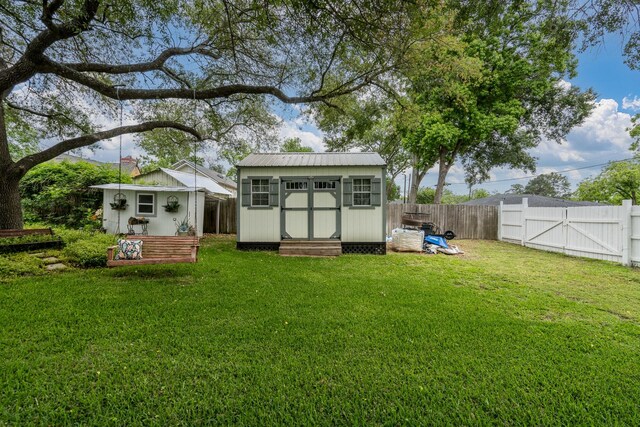 view of shed featuring a fenced backyard and a gate