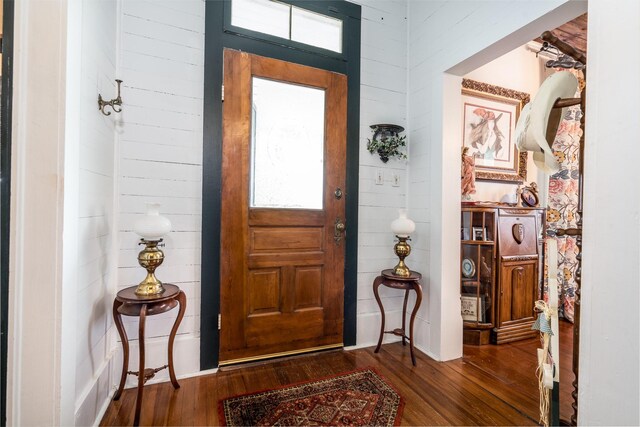 foyer entrance featuring wood-type flooring and wood walls