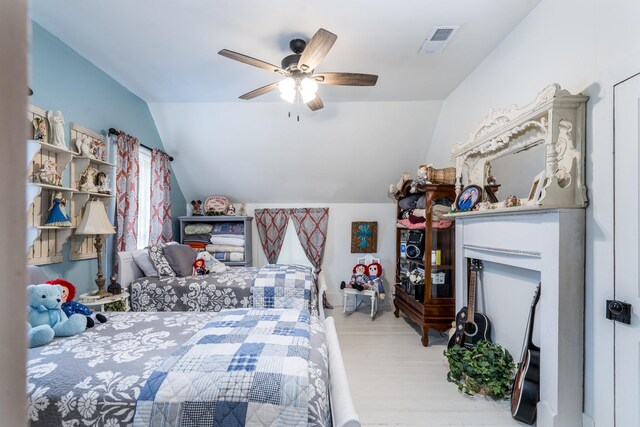 bedroom with light wood-type flooring, a ceiling fan, vaulted ceiling, and visible vents
