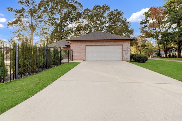 view of side of property with fence, roof with shingles, brick siding, a yard, and driveway
