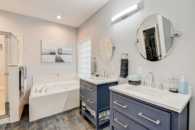 bathroom with a sink, a bath, a stall shower, and two vanities