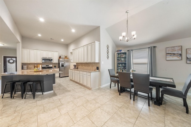 kitchen featuring backsplash, a chandelier, light stone countertops, and appliances with stainless steel finishes