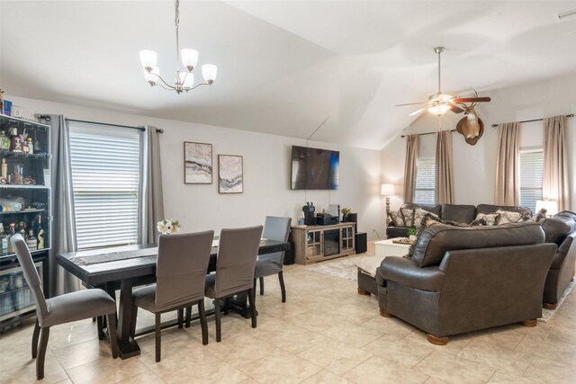 dining area with visible vents, light tile patterned floors, lofted ceiling, and ceiling fan with notable chandelier