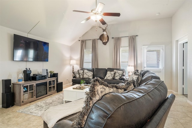 living area with a ceiling fan, baseboards, light tile patterned floors, and lofted ceiling
