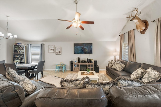 living area featuring baseboards, ceiling fan with notable chandelier, and vaulted ceiling