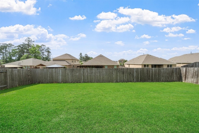 view of yard featuring a fenced backyard and a residential view