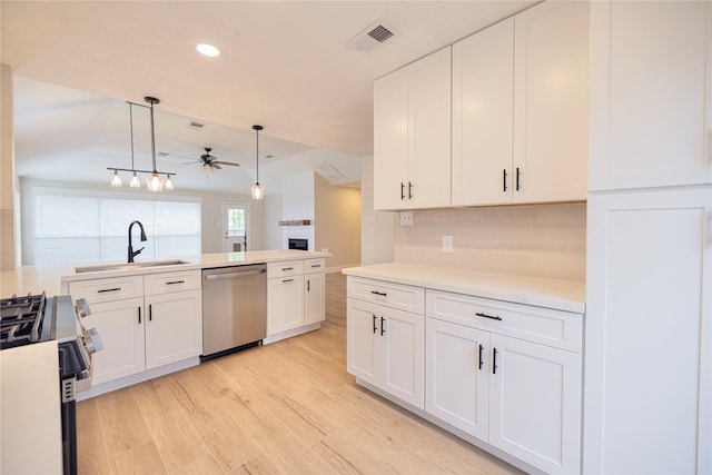 kitchen with a ceiling fan, light wood-type flooring, white cabinets, a sink, and stainless steel appliances