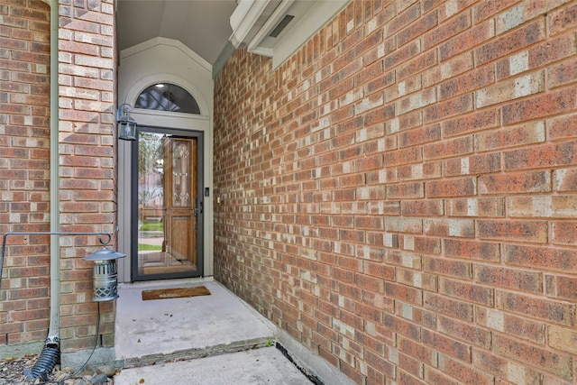 view of exterior entry with brick siding