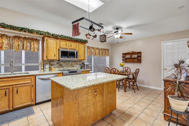 kitchen featuring decorative backsplash, a ceiling fan, a sink, stainless steel appliances, and light tile patterned flooring