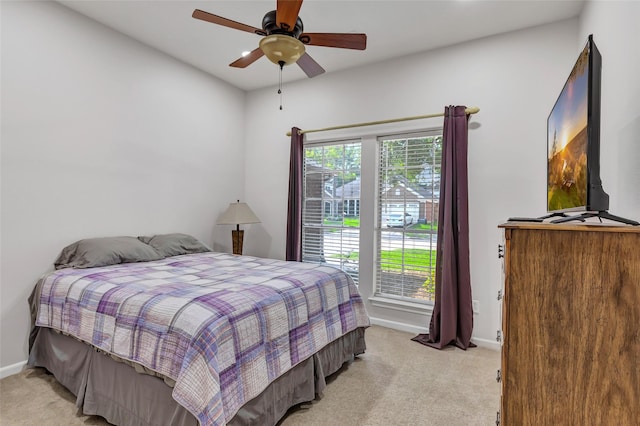 bedroom with baseboards, a ceiling fan, and light carpet