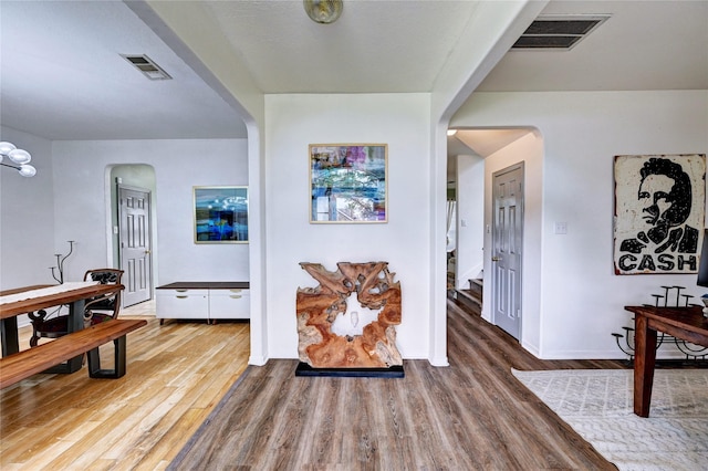 interior space featuring visible vents, arched walkways, and wood finished floors