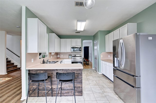 kitchen featuring visible vents, a sink, appliances with stainless steel finishes, and light countertops
