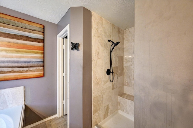 full bathroom featuring a textured ceiling, baseboards, and tiled shower