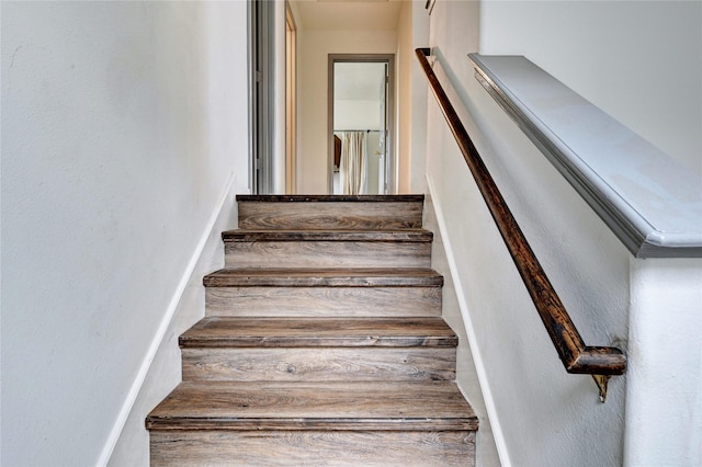 staircase featuring a textured wall