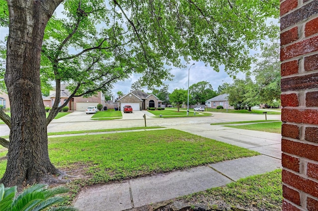 view of yard featuring driveway and a residential view