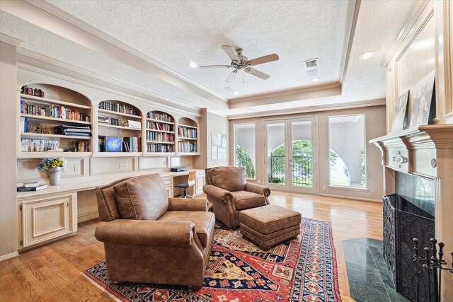 1623 Scenic Shore Dr, Kingwood, TX 77345 - living area featuring a textured ceiling, built in desk, a healthy amount of sunlight, and ceiling fan