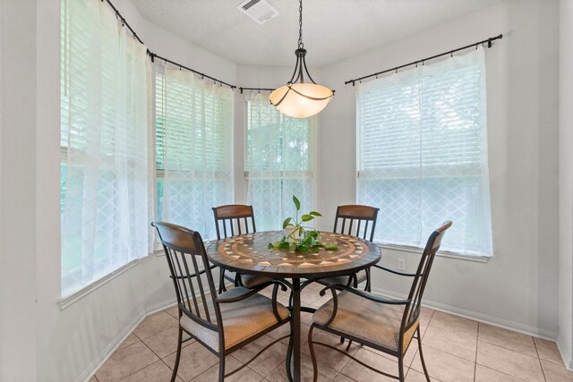dining space featuring visible vents, baseboards, and light tile patterned floors