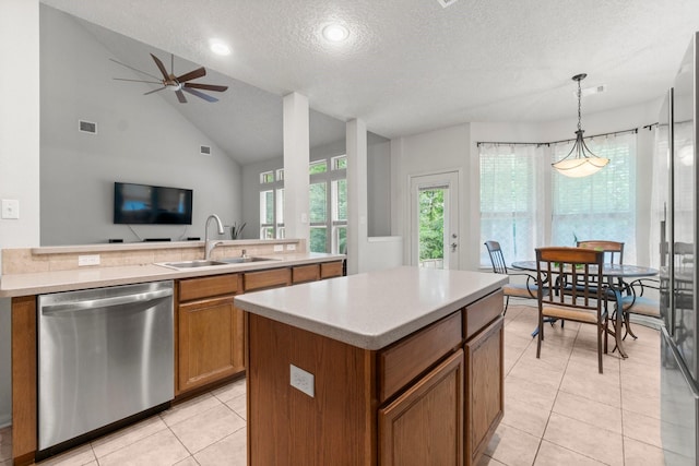 kitchen featuring stainless steel dishwasher, brown cabinetry, visible vents, a textured ceiling, and a sink