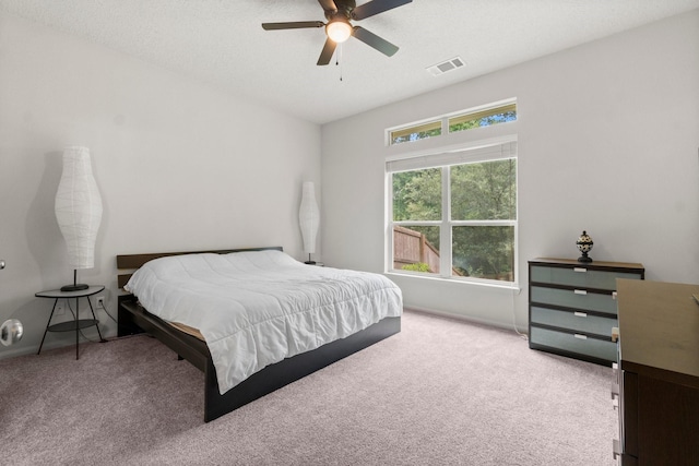 bedroom featuring ceiling fan, visible vents, and carpet