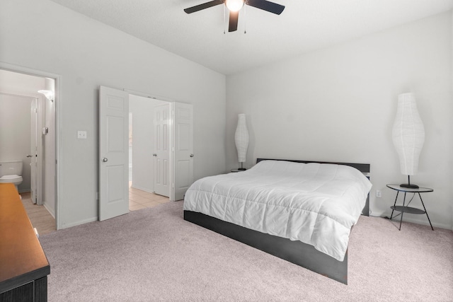 bedroom with baseboards, ceiling fan, light carpet, and connected bathroom
