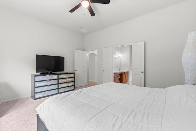 carpeted bedroom featuring a ceiling fan, baseboards, a sink, and ensuite bathroom