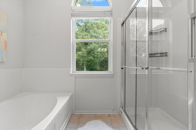 bathroom with tile patterned flooring, a bath, and a stall shower