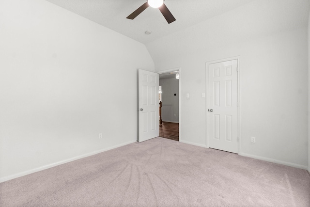 unfurnished bedroom featuring carpet floors, baseboards, a ceiling fan, and vaulted ceiling