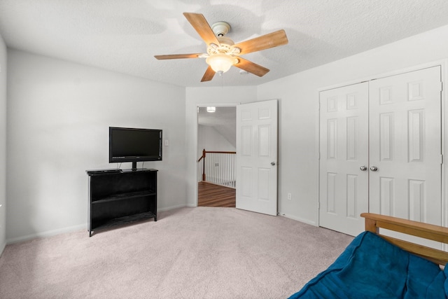 bedroom featuring carpet floors, baseboards, a ceiling fan, and a closet