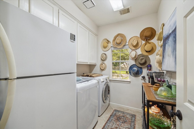 clothes washing area featuring independent washer and dryer, visible vents, cabinet space, baseboards, and light tile patterned flooring