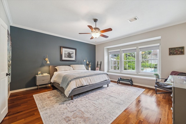 bedroom with crown molding, baseboards, dark wood finished floors, and visible vents
