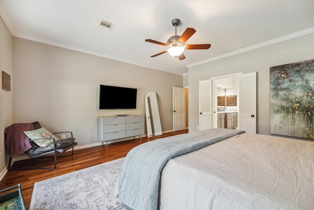 bedroom with baseboards, ornamental molding, wood finished floors, and visible vents