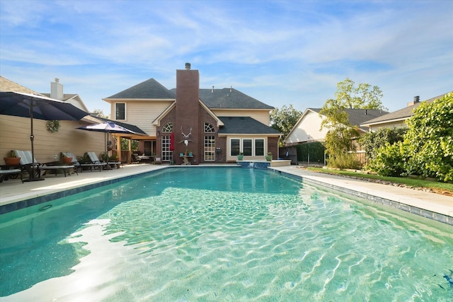 outdoor pool featuring a patio area and fence