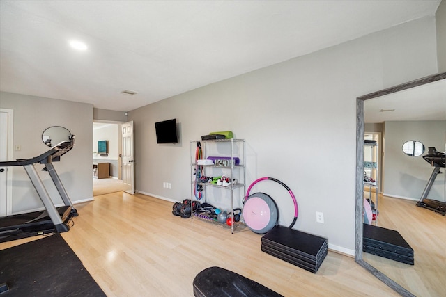 exercise room featuring baseboards and wood finished floors