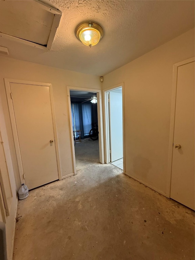 empty room with a textured ceiling and concrete flooring