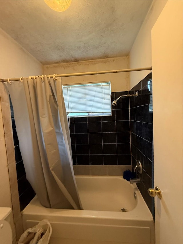 bathroom featuring toilet, a textured ceiling, and shower / bath combination with curtain