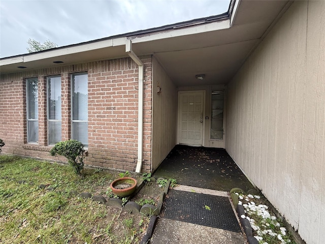 doorway to property featuring brick siding
