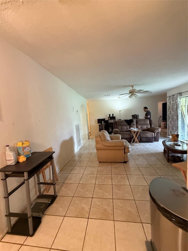 living area with visible vents, ceiling fan, and light tile patterned floors