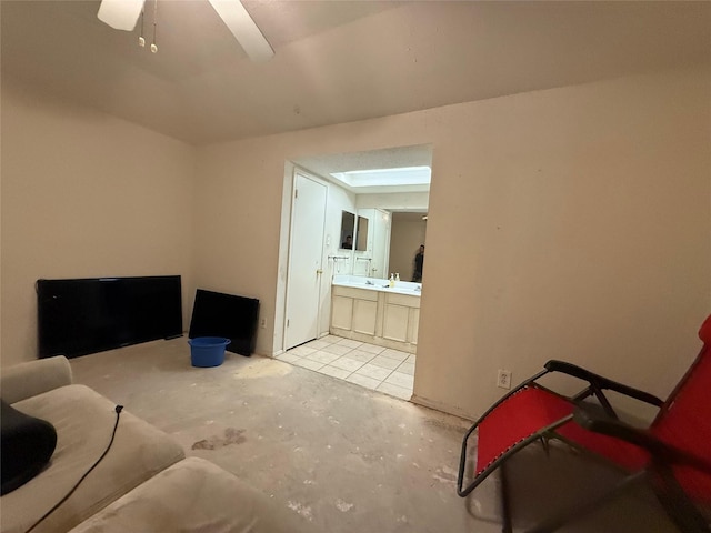 sitting room with unfinished concrete floors and a ceiling fan