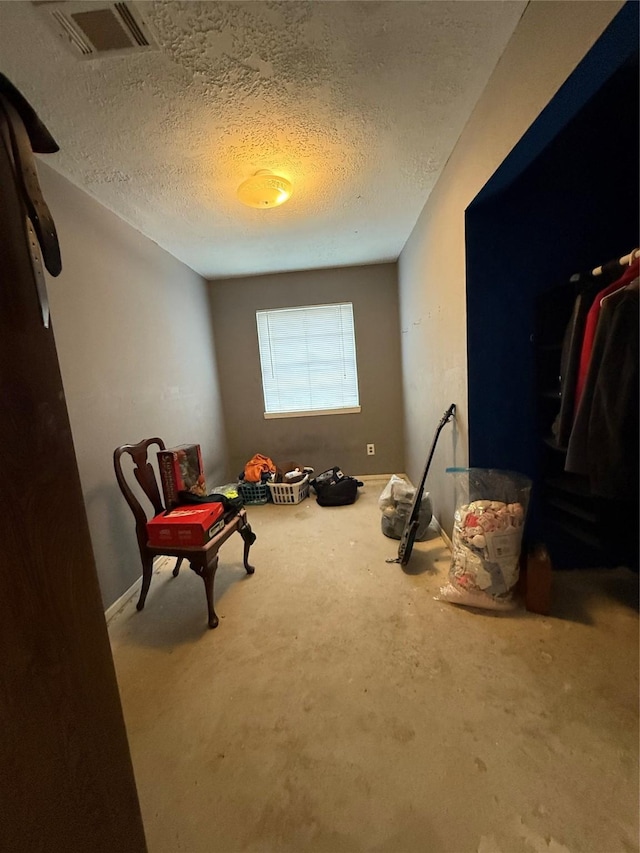 sitting room featuring visible vents and a textured ceiling