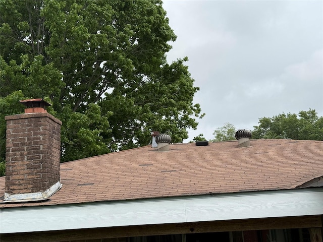 exterior details with a chimney and roof with shingles