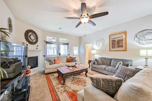 carpeted living area with a glass covered fireplace, ceiling fan, and visible vents